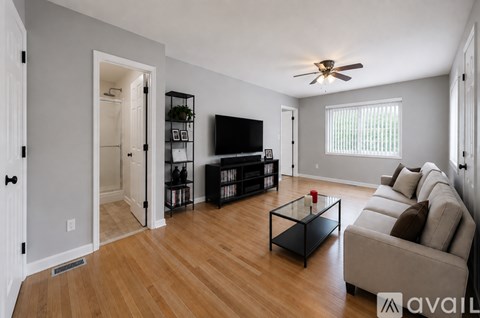 A living room with a black coffee table and a flat screen TV.