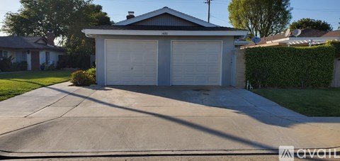 A two-car garage with a white door is situated in a residential area.