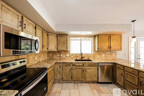 A kitchen with wooden cabinets and a black stove top oven.