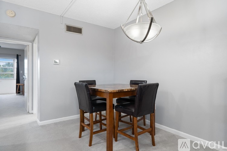 A dining room with a table and chairs.