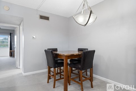 A dining room with a table and chairs.
