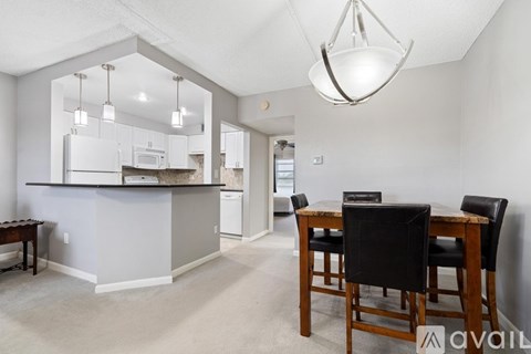A kitchen with a dining table and chairs.