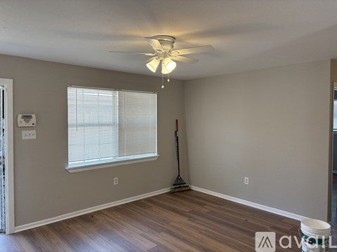 A room with a ceiling fan and a window with blinds.