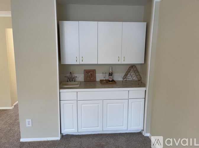 A kitchen with white cabinets and a sink.