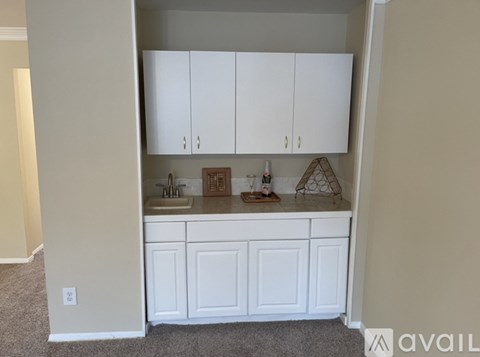 A kitchen with white cabinets and a sink.