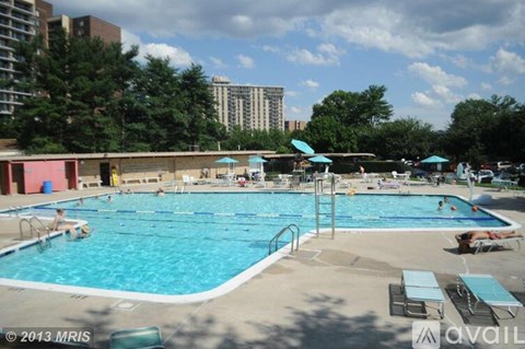 A large outdoor swimming pool with people in it.