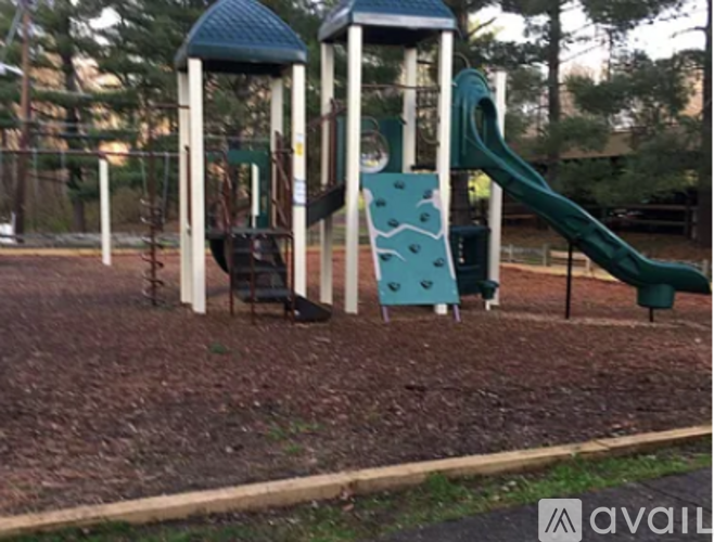 A playground with a green slide and a blue and white structure.