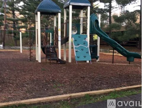 A playground with a green slide and a blue and white structure.