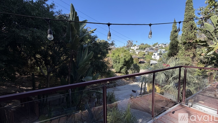 A balcony with a view of a garden and trees.