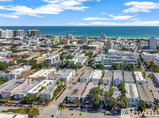 A cityscape with buildings and palm trees in the foreground.