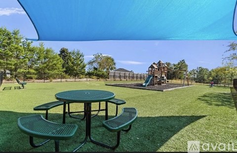 A park with a picnic table and a playground in the background.