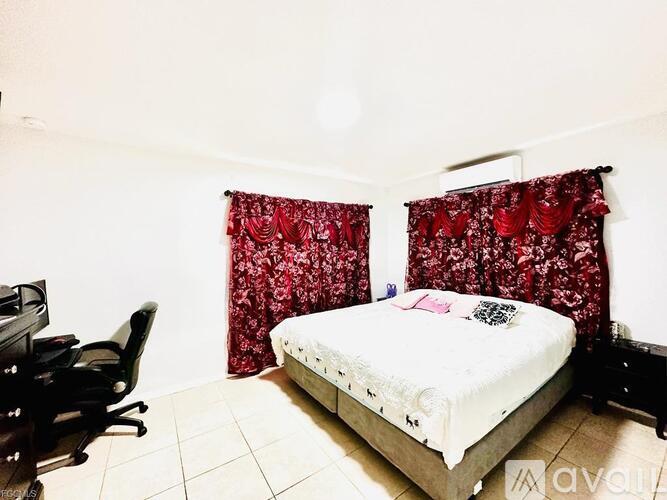 A bedroom with a bed, desk, and chair.