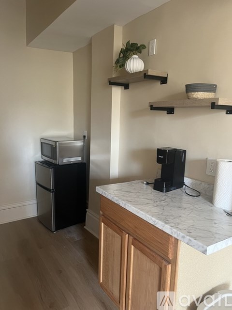 A kitchen with a white counter top and wooden cabinets.