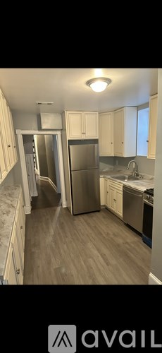 A kitchen with wooden cabinets and a stainless steel refrigerator.
