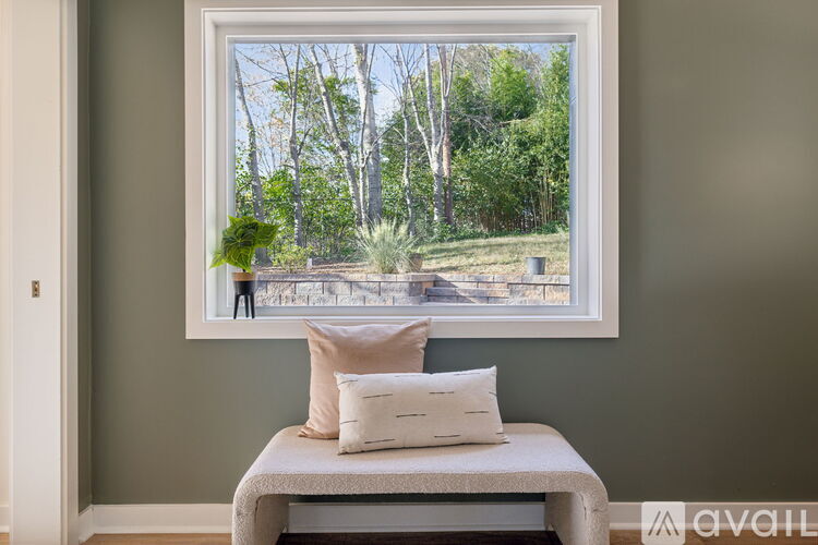 A window with a view of trees and a lawn.