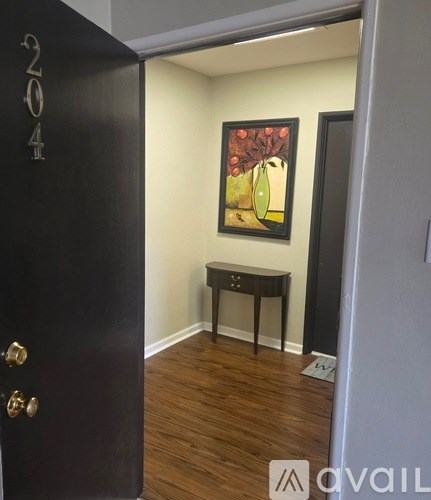 A long hallway with a bench and picture on the wall.