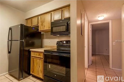 A kitchen with black appliances and wooden cabinets.