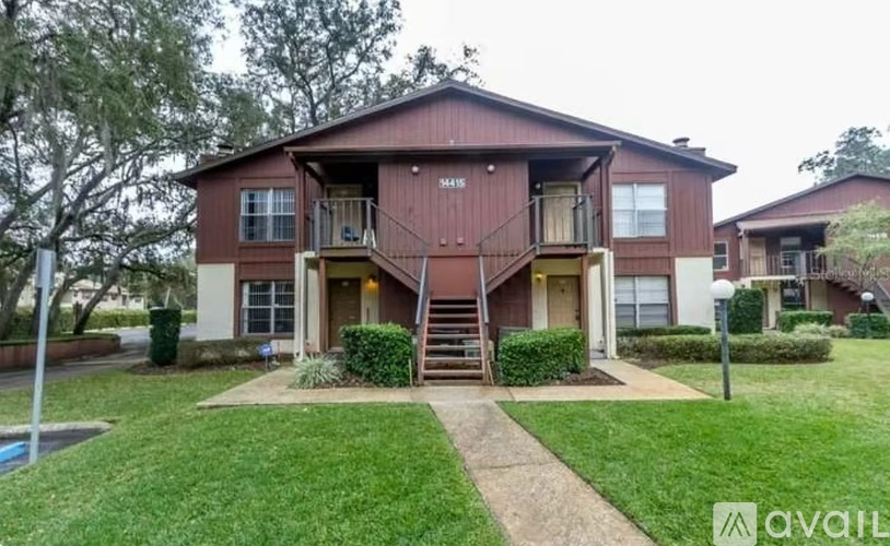 A two-story house with a red and beige exterior and a front porch.