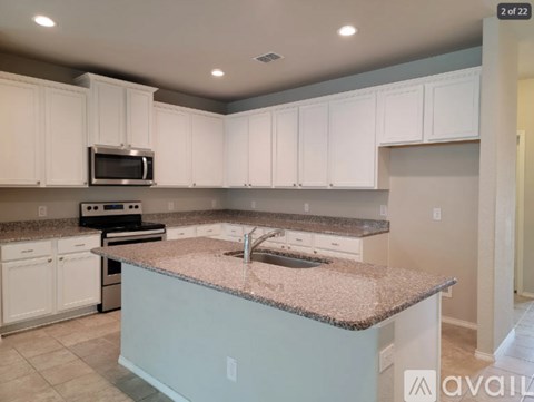 A kitchen with white cabinets and a granite countertop.