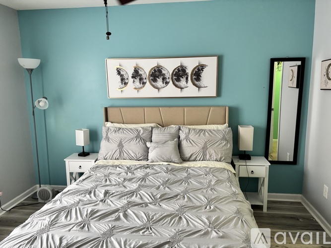 A bedroom with a bed, nightstands, and a ceiling fan.