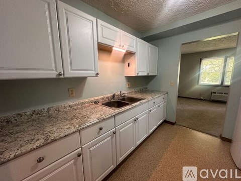 A kitchen with white cabinets and granite countertops.