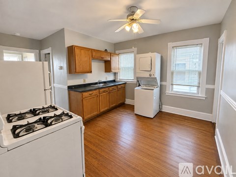 A kitchen with a white stove and wooden cabinets.