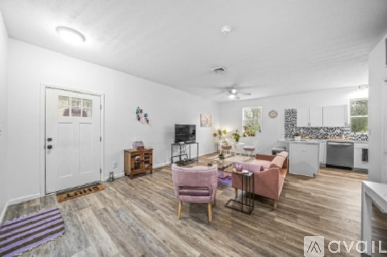 A living room with a pink chair and a white door.