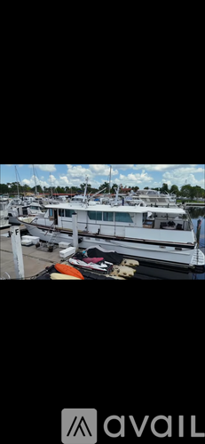 A boat is docked at a marina with other boats in the background.