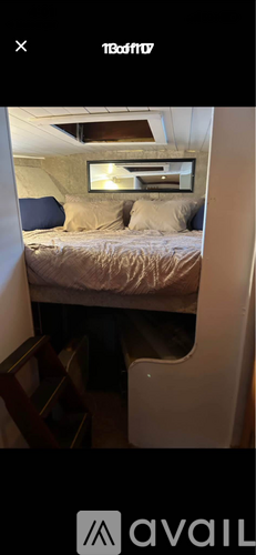 A bedroom with a bed, a chair, and a mirror on the wall.
