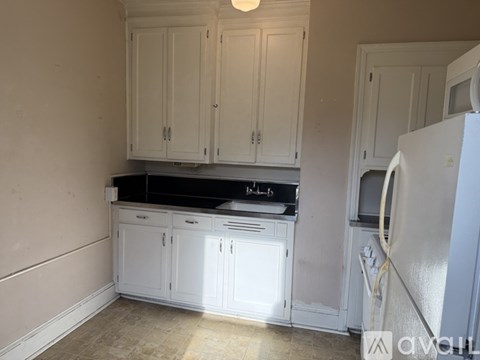 A kitchen with white cabinets and a black stove top.