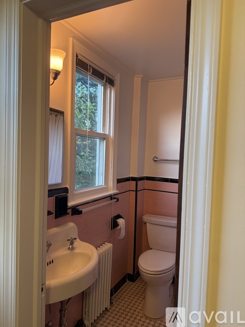 A white fridge in a room with a window and a door.