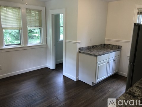 A room with a marble countertop and wooden flooring.