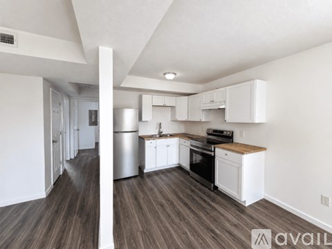 A kitchen with white cabinets and a wooden countertop.