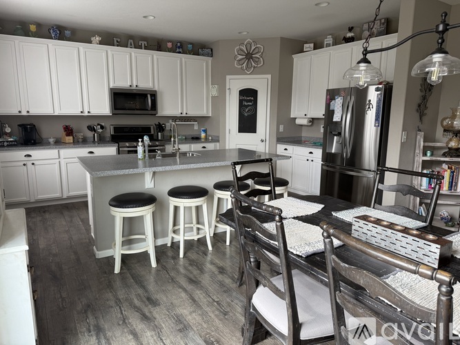 A kitchen with white cabinets and a black fridge.