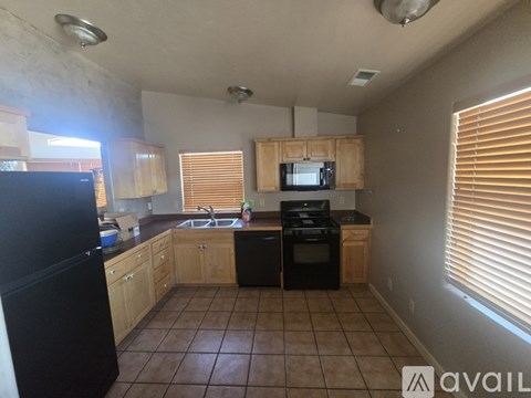 A kitchen with black appliances and wooden cabinets.
