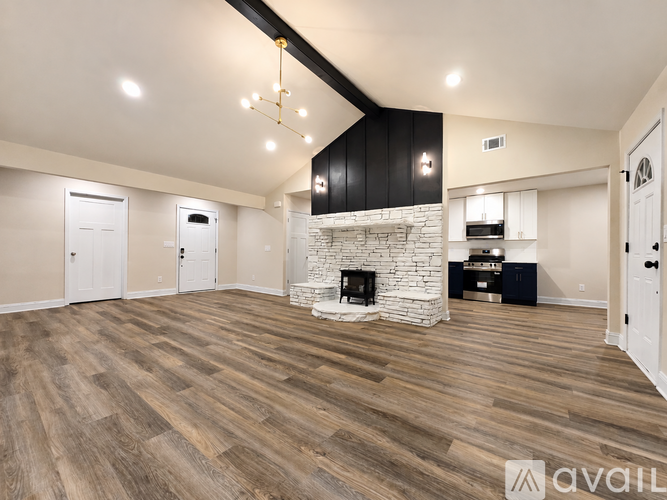 A spacious living room with a fireplace and wooden flooring.