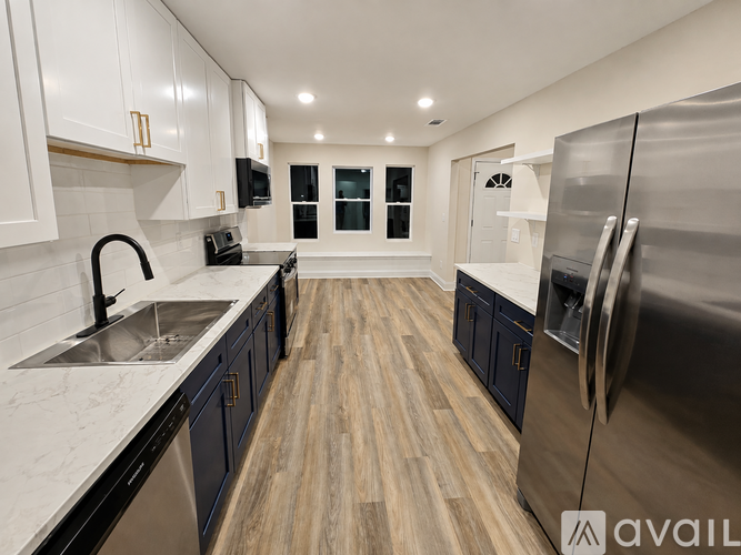 A modern kitchen with dark blue cabinets and stainless steel appliances.