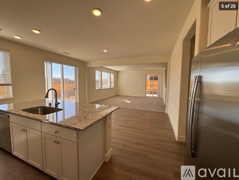 A kitchen with a granite countertop and stainless steel appliances.