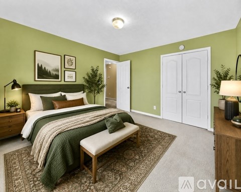 A bedroom with a large bed and a bench in front of it.