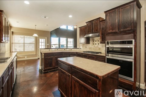 A kitchen with dark wood cabinets and a center island.