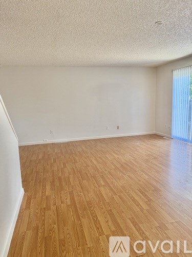 A room with wooden flooring and white walls.