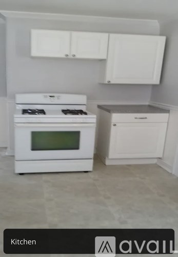 A white kitchen with a stove and a drawer unit.