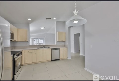A kitchen with white cabinets and black appliances.