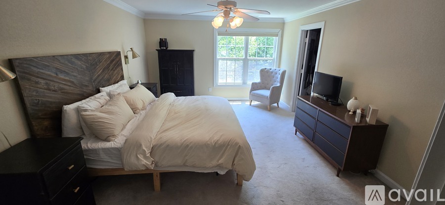 A bedroom with a large bed and a flat screen TV.