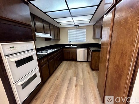 A kitchen with wooden cabinets and a white oven.