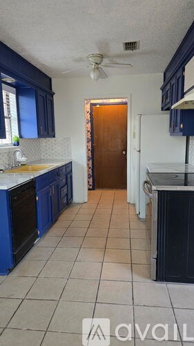 A kitchen with blue cabinets and a white ceiling.