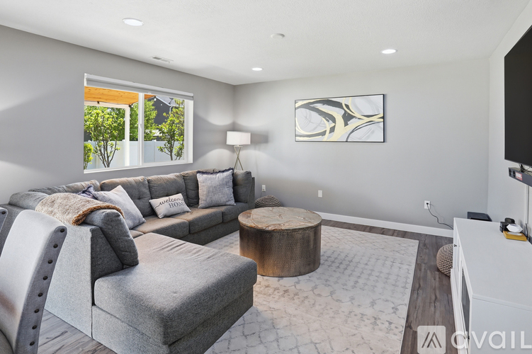 A modern living room with a grey sofa and a wooden coffee table.