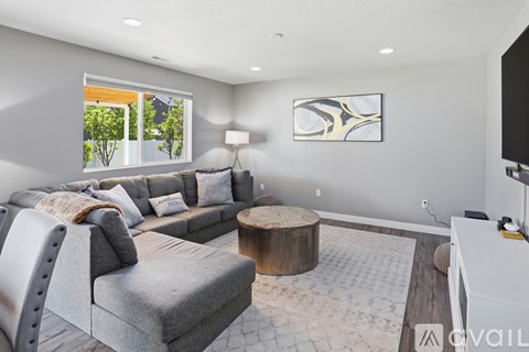 A modern living room with a grey sofa and a wooden coffee table.