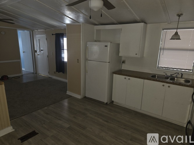 A kitchen with a white refrigerator and wooden floors.