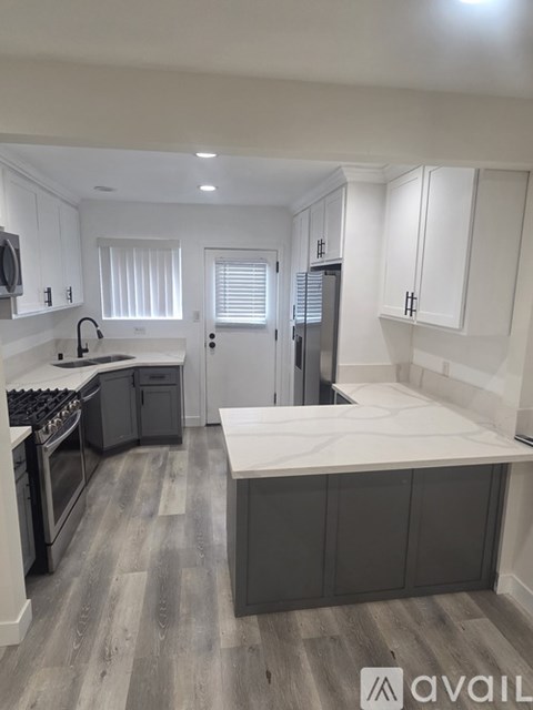 A kitchen with a white countertop and grey cabinets.